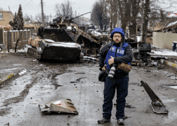 Photographer Serhii Nuzhnenko takes photos of a broken Russian convoy in Bucha near Kyiv, March 1, 2022. Photo: Stas Yurchenko / Graty