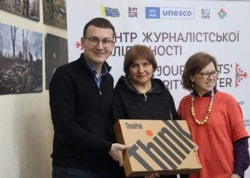 Head of the NUJU Serhii Tomilenko and First Secretary Lina Kush handing a laptop to Larysa Salimonovych.