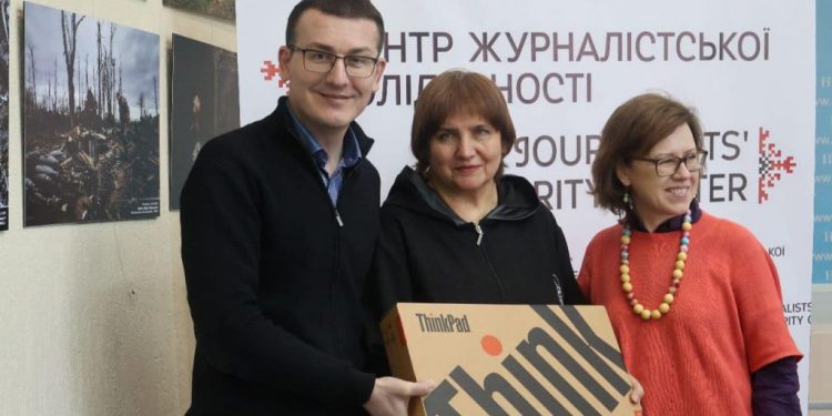 Head of the NUJU Serhii Tomilenko and First Secretary Lina Kush handing a laptop to Larysa Salimonovych.