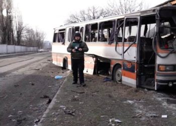 PHOTO: Suspilne Dnipro Correspondent Anton Sirenko in the Background of a Bus with Miners Destroyed by a Strike. Photo: Suspilne
