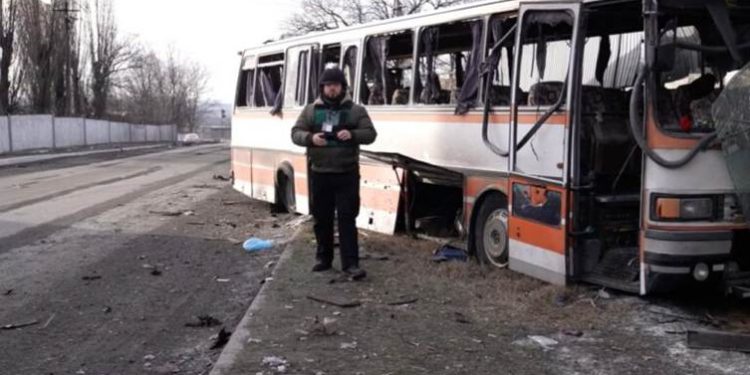 PHOTO: Suspilne Dnipro Correspondent Anton Sirenko in the Background of a Bus with Miners Destroyed by a Strike. Photo: Suspilne
