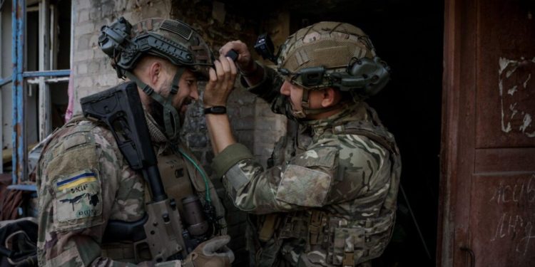 “Watching our videos makes the enemy surrender,” says Ivan Petrychak, 24th Brigade press service head 1 Press officer Ivan Petrychak adjusting the camera of the Skifa sniper before the combat exit, the central part of the city of Chasiv Yar, 2025. Photo by Oleh Petrasiuk.