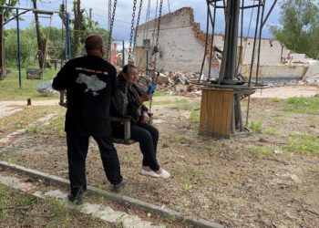 Sergiy Tomilenko: “Where the connection ends: the most dangerous newspaper route” 12 Nataliia Pasiuha, holding the Chuyka drone detector, sits on a swing in the frontline village of Spirne. Behind her lie the ruins of the café that served as a distribution point for Vorskla